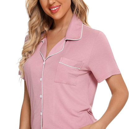 Woman wearing a pink pajama top with white trim on a white background