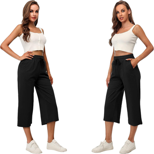 Woman wearing a white crop top and black pants on a white background