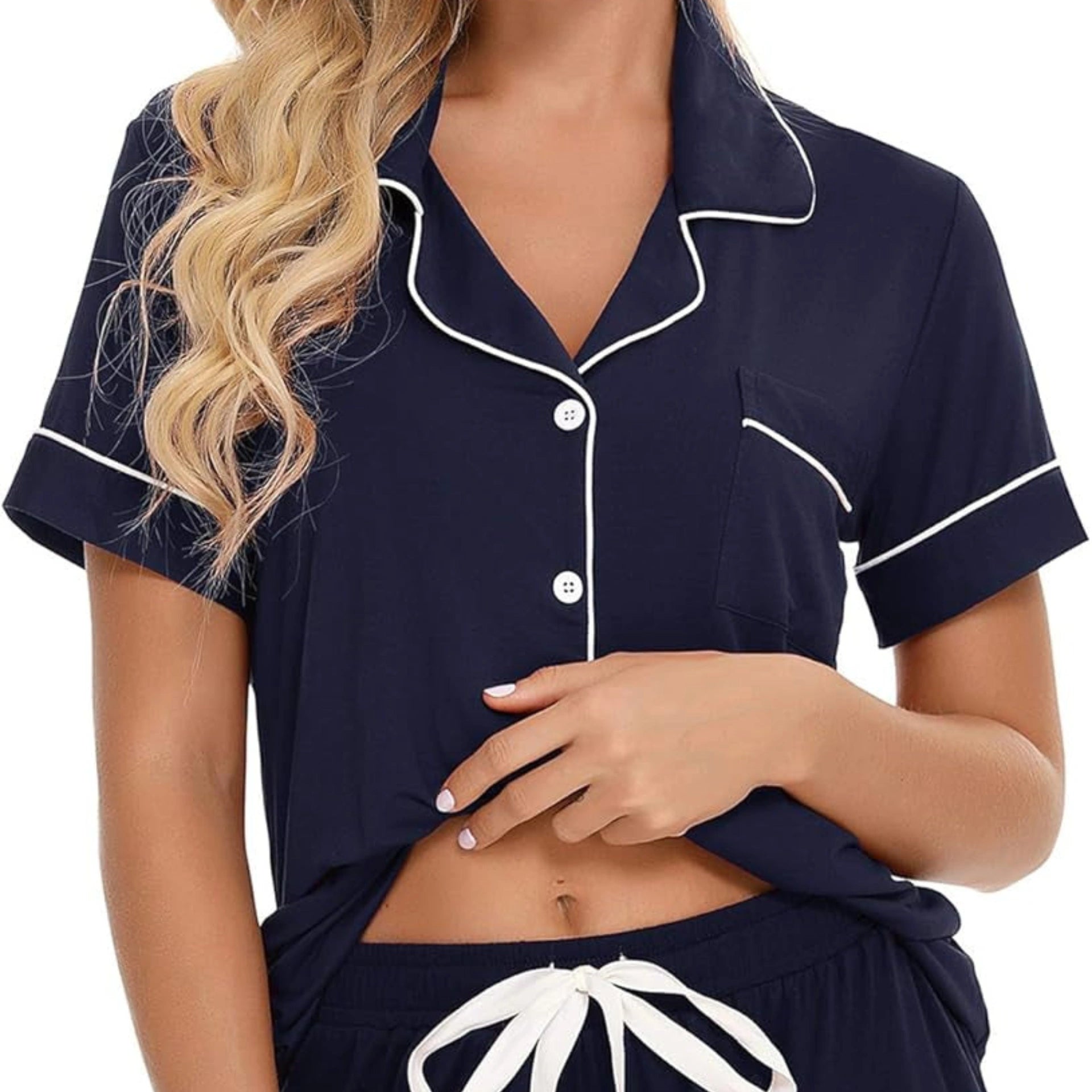Navy blue pajama set with white trim worn by a model on a white background