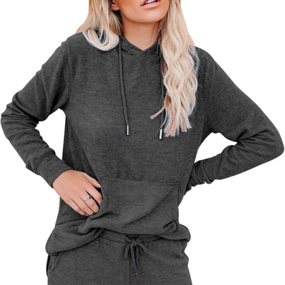 Person wearing a dark gray hoodie and pants on a white background
