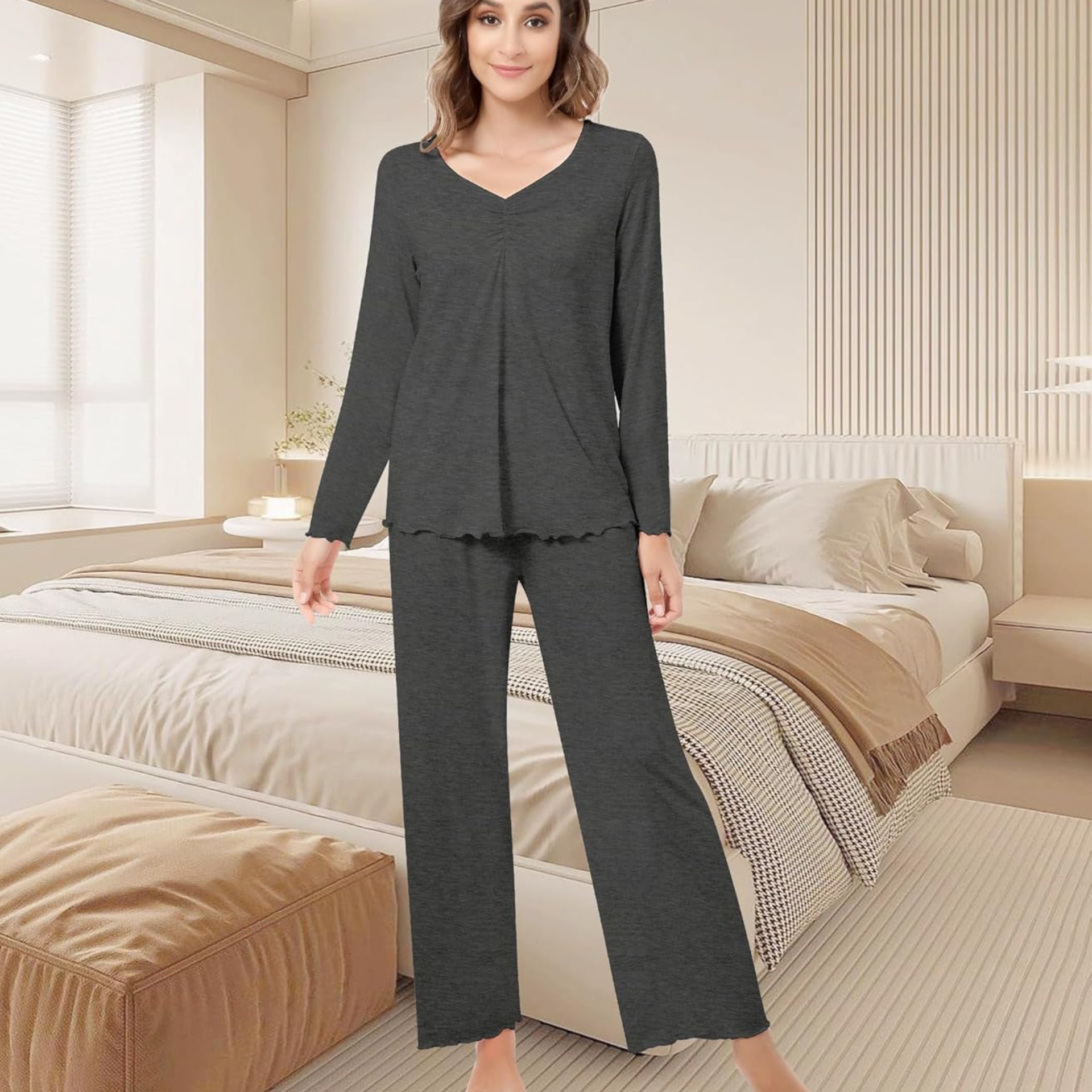 Woman wearing a dark gray pajama set in a bedroom.