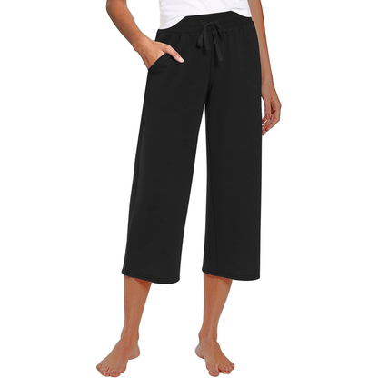 Person wearing black capri pants on a white background