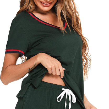 Woman wearing a dark green outfit with red trim on a white background