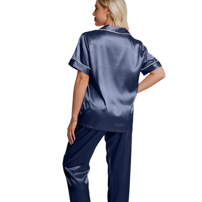 Woman wearing a navy satin pajama set on a white background