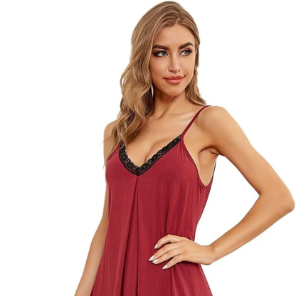 Woman wearing a red slip dress with black lace trim on a white background